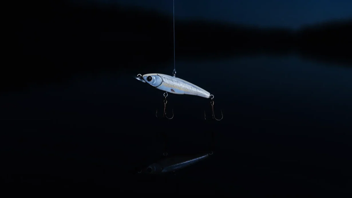 Blank fiskeblink i sølv og perlemor som henger over helt stille, svart vann